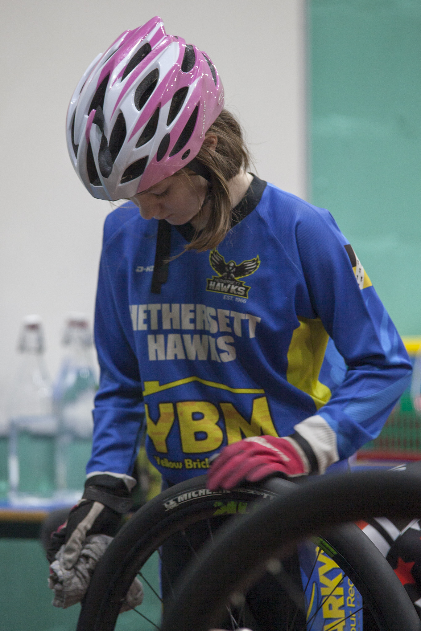 A young rider cleans her tyres for indoor racing