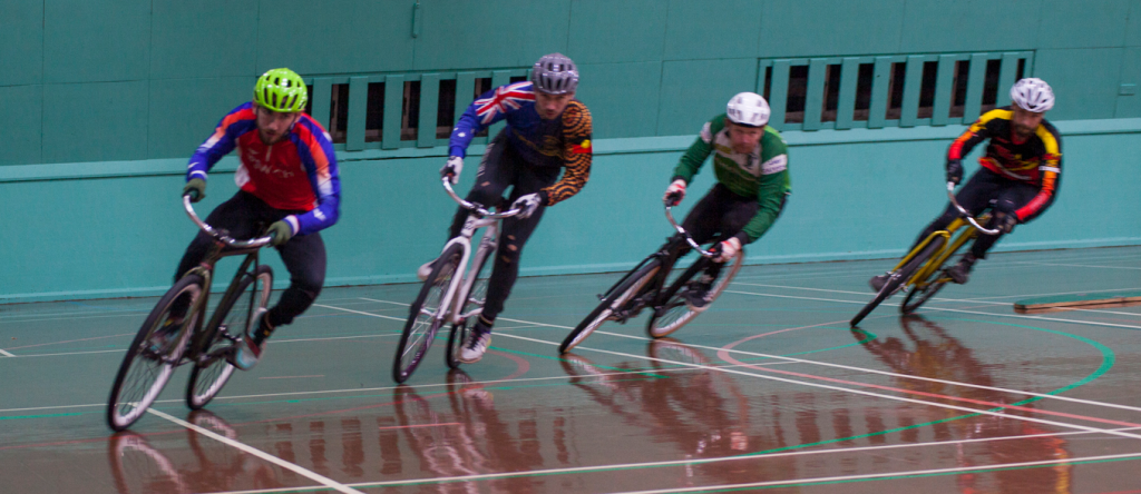 Four senior riders racing indoors