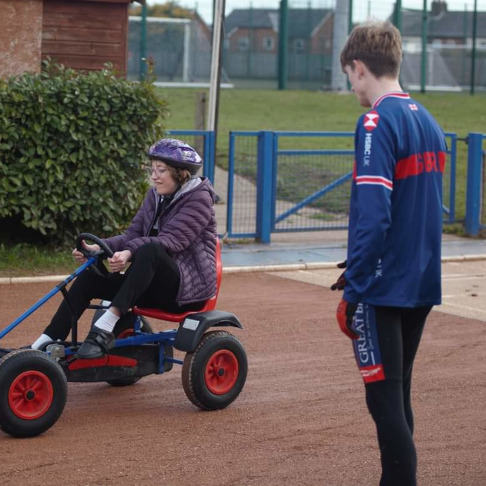 A coach helps a young rider to enjoy safe traffic-free riding